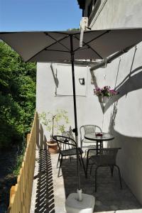 - une table et des chaises sous un parasol sur la terrasse dans l'établissement Mill Valley Appart, à Coblence