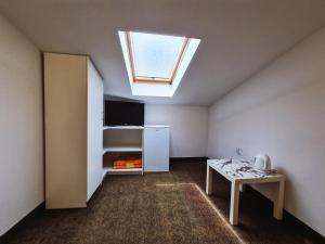 ein kleines Zimmer mit einem Dachfenster und einem Tisch darin in der Unterkunft Guest house Davorka in Neum