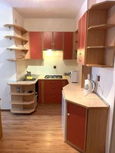 una cucina con armadi rossi e un apparecchio bianco di Apartament KRYNICZANKA a Krynica Morska