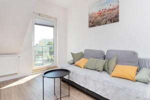 a living room with a couch and a window at Apartments Gdańsk Kochanowskiego by Renters in Gdańsk