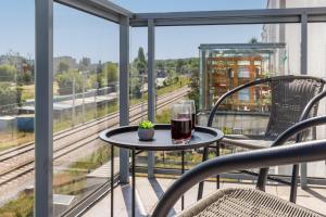a glass of wine on a table on a balcony at Apartments Gdańsk Kochanowskiego by Renters in Gdańsk