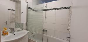 a white bathroom with a shower and a sink at govienna - Messe Wien Apartment in Vienna