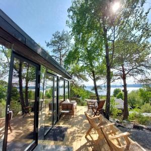 a glass house with a patio with a table and benches at fjord : oslo 