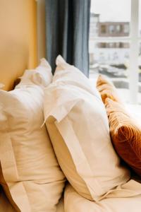a pile of pillows on a bed with a window at Number 9 holiday apartments in Middelburg +10 photos