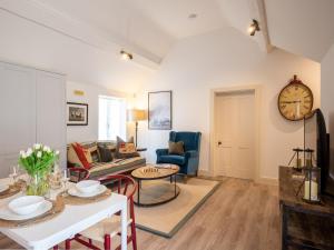 a living room with a couch and a clock on the wall at The Fold in Charlbury