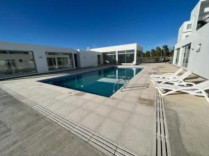 a house with a swimming pool next to a building at Departamento premium para 3 personas in Puerto Madryn
