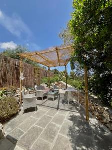 une terrasse avec une pergola, des tables et des chaises dans l'établissement STONE Home - Sea & Landscape, à Marittima