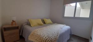 una camera da letto con un letto con cuscini gialli e una finestra di Hermoso departamento muy bien ubicado, cercano calle Aristides a Mendoza