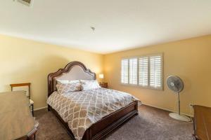 Family-friendly 4BR Home - Spacious - Great Location في فونتانا: غرفة نوم بسرير ونافذة ومروحة