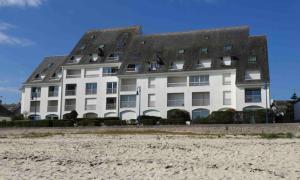 un gran edificio blanco en la playa junto a la arena en Ker Lafranec'h - Face Mer et Plage, 2 Chambres, WiFi, en Saint-Pierre-Quiberon