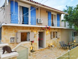 a cat sitting on the ledge of a house at Spiro's cottage by Alegria apartments in Vlachopoulátika