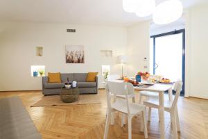 uma cozinha e sala de estar com mesa e cadeiras em Sweet Inn - Maison Laghetto em Milão