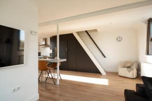a kitchen and living room with a staircase in a house at Sky View in Tilburg