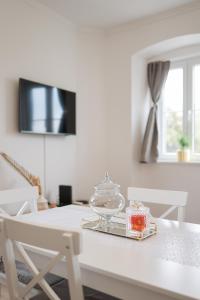 een witte tafel met een bord cake erop bij Sea Gate Apartment in Zadar