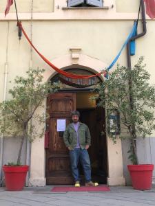 un hombre parado frente a una puerta de madera en Palazzo Dodici Rondini, en Foligno