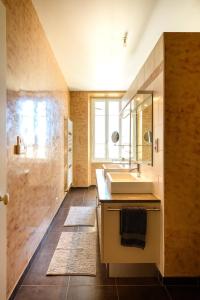 ein Bad mit einem Waschbecken und einem Spiegel in der Unterkunft Mas Viticole Les Cardelines with swimming pool - by feelluxuryholidays in Vacqueyras