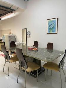 een eetkamer met een marmeren tafel en stoelen bij Homestay Taman Sri Nibong 庆丰园 in Nibung Tebal