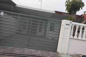 een metalen garagedeur aan de zijkant van een huis bij Homestay Taman Sri Nibong 庆丰园 in Nibung Tebal