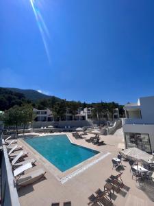 einen Pool mit Liegestühlen und ein Resort in der Unterkunft Mythical Coast Wellness Retreat in Mytilini