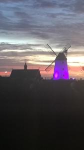 a windmill with a purple light in front of a sunset at Clifton Lodge in Lytham St Annes