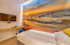 een slaapkamer met een schilderij van het strand bij Riverview Apartament Waterline SPA & Pool in Gdańsk +8 foto's