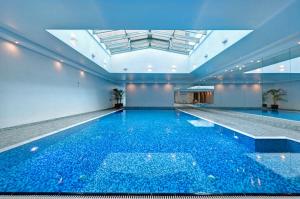 a swimming pool with blue water in a building at Riverview Apartament Waterline SPA & Pool in Gdańsk