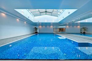 een zwembad met blauw water in een gebouw bij Riverview Apartament Waterline SPA & Pool in Gdańsk