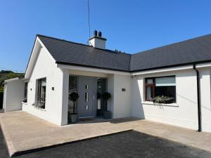 a white house with a garage at The Hillcrest, Luxury Accommodation in Castleblayney Town in Castleblayney