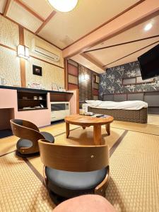 sala de estar con cama, mesa y sillas en ホテル水明, en Koriyama