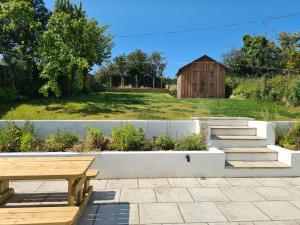 a patio with a wooden bench and a barn at Cippinstone in Newport Pembrokeshire