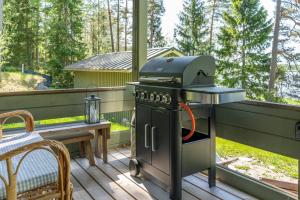 a grill on a deck with a table and a bench at Traditional Seaside Cottage 