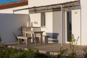 a wooden porch with a bench and a table at Cucumbi in Santa Susana