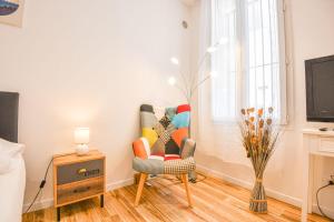 uma sala de estar com uma cadeira e uma televisão em Studio neuf avec AC proche Castellane et métro em Marselha