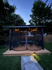 a gazebo with lights on it in a yard at Stylish Downtown Kingsville Getaway with Putting Green, Firepit & Games in Kingsville