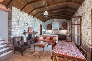 a living room with a table and a stone wall at Big Blue Pelion in Pilion