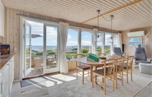 uma sala de jantar com uma mesa e vistas para o oceano em Cozy Home In Faaborg With Kitchen em Faaborg