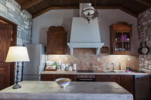 a kitchen with wooden cabinets and a table with a lamp at Big Blue Pelion in Pilion +37 photos