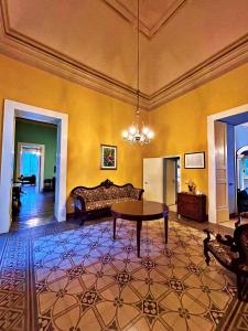 un soggiorno con tavolo e divano di Palazzo Galluccio a Galatina