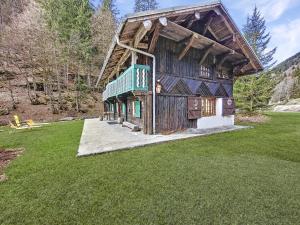 モントリオンにあるChalet Ardent Montriond 8 personnesの芝生のフィールドに建つ緑の屋根の木造家屋