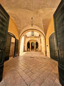 un corridoio vuoto in un vecchio edificio con soffitto di Palazzo Galluccio a Galatina