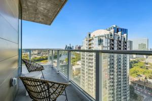 a balcony with two chairs and a view of a city at 21st FL 2BD Condo-Rainey St-Best views in Austin