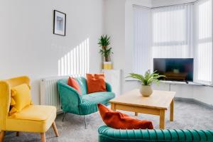 a living room with two chairs and a table at Cosy 3 bedroom house near Anfield Stadium in Liverpool