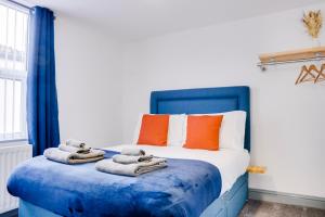 a bedroom with a blue bed with towels on it at Cosy 3 bedroom house near Anfield Stadium in Liverpool