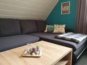 ein Wohnzimmer mit einem Sofa und einem Tisch in der Unterkunft Ferienwohnung im Fehnland 35667 in Uplengen