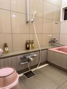 un baño con una manguera conectada a una ducha en ホテル水明, en Koriyama