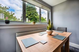 - une table en bois dans une chambre avec fenêtre dans l'établissement Hudson Apartment, à East Kilbride