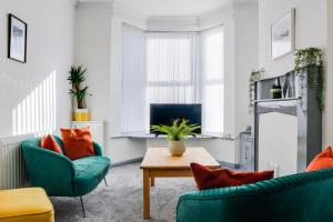 a living room with two chairs and a table at Cosy 3 bedroom house near Anfield Stadium in Liverpool