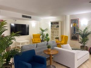 a living room with a gray couch and yellow chairs at AZ Orús Factory Hotel - Parking Gratuíto in Zaragoza