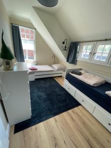1 dormitorio con 2 camas y alfombra en Luxus Lindenhof Apartments -Ferienwohnungen in Friesland an der Nordsee am Naturschutzgebiet Urwald, en Neuenburg