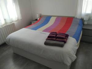 uma cama com cobertor colorido e duas toalhas em Casa Poblamar em Pobla de Montornés